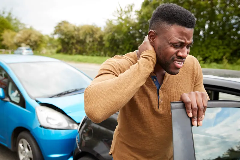 A driver holding his neck after a collision