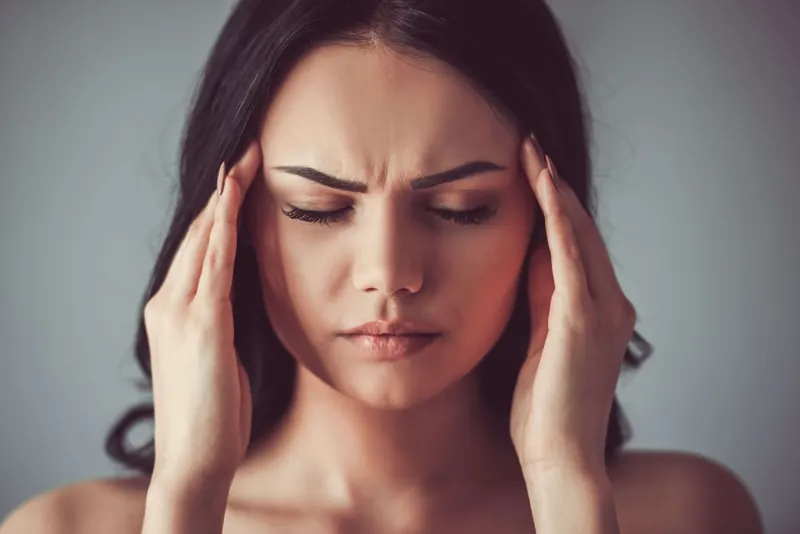 A woman holding her head with a headache