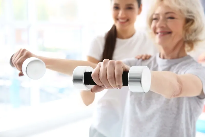 A patient exercising with light dumbbells