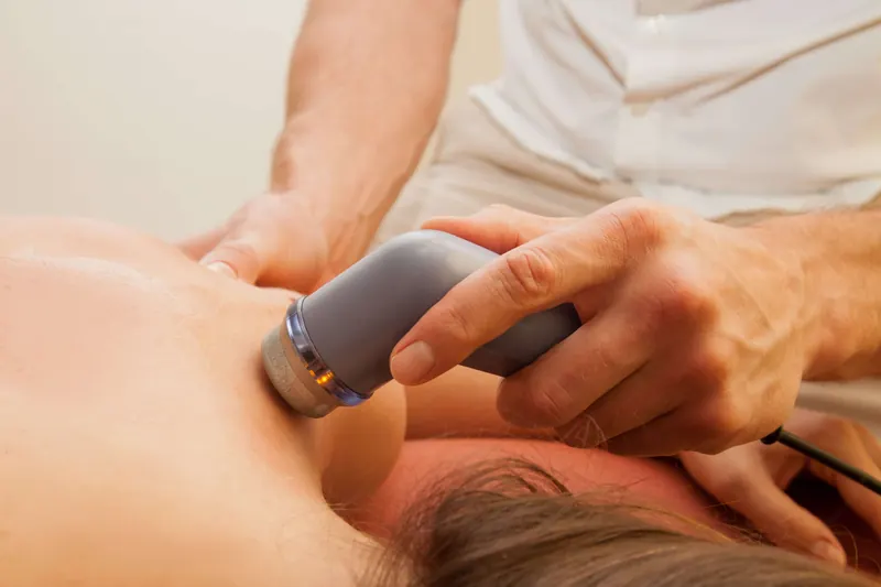A handheld therapy device applied to a patient's arm